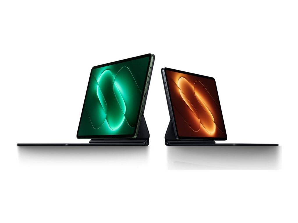 Two Xiaomi Pad 9 Pro tablets on their floating keyboards, one screen lit in green, the other in orange